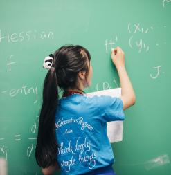 SUMaC student writing on chalkboard